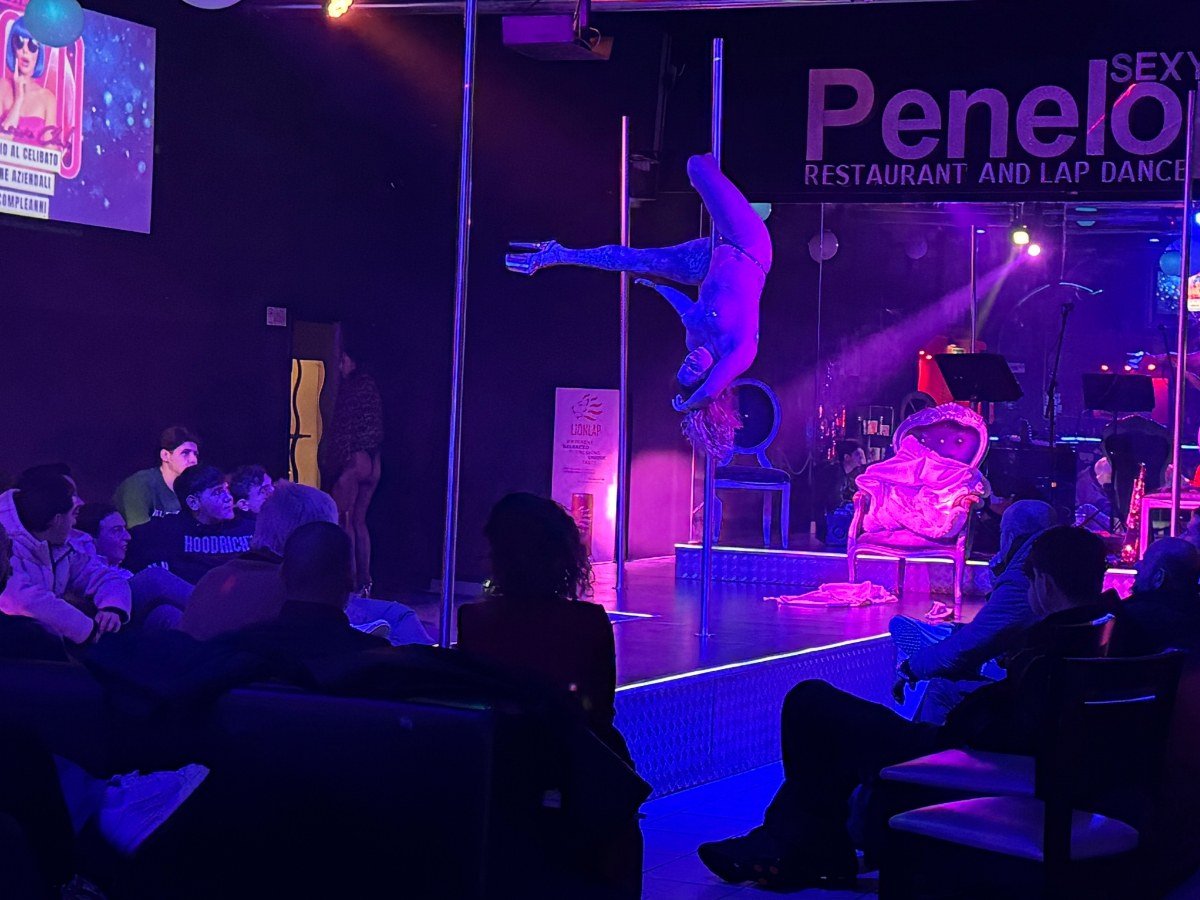 Performer sul palco durante lo show, gruppo di uomini che ride e applaude
