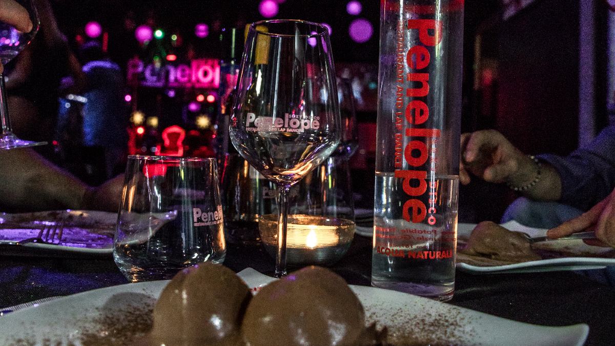 Tavolo con torta e candele per compleanno adulti Pontedera, gruppo di amici intorno, atmosfera calda