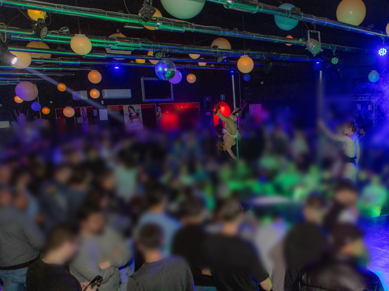 Performer sul palco durante lo show, luci di scena, pubblico che applaude e partecipa